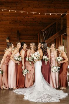 a group of women standing next to each other in front of a wooden wall with lights