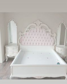 a white bed with pink tufted headboard and foot board in a bedroom setting