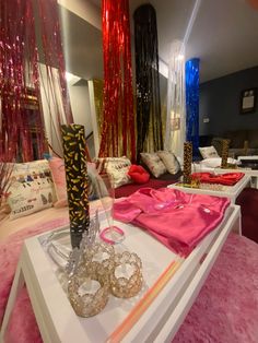 a table with some pink and gold items on it in a room filled with furniture