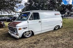 an old van is parked in the grass