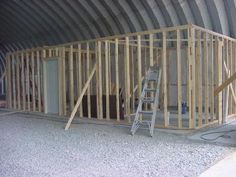 the inside of a building being built with wooden framing and ladders on the floor