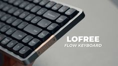 a hand holding a black keyboard with the words lofree below it that reads flow keyboard