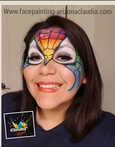 a woman with her face painted like a hot air balloon, smiling at the camera