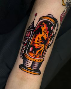 a tattoo on the arm of a person with a fire in a jar and flames coming out of it