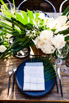 a table set with flowers and place settings