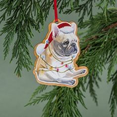 a christmas ornament hanging from a tree with a pug wearing a santa hat