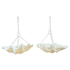 two silver and gold seashells hanging from chains