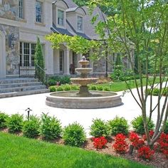 a large house with a fountain in the front yard