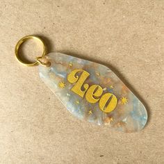 a keychain with the word go written on it and stars in gold lettering