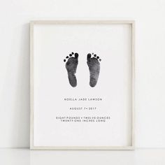 a black and white photo with a baby's foot print on the wall next to it