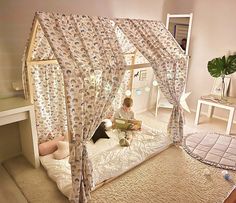 a child is sitting on a bed with a canopy over it and reading a book