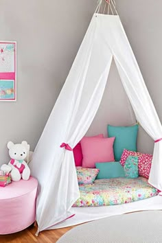 a child's bedroom with a teepee tent bed and pink furniture in the corner