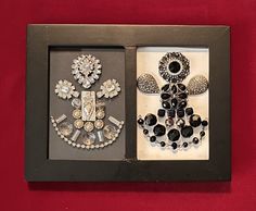 two pieces of jewelry are displayed in a black frame on a red wall behind them