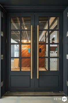 the front door to an office building with glass doors and wood paneling on both sides