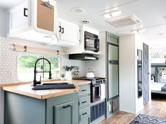 a kitchen with green cabinets and white walls