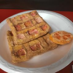 two waffles are sitting on a plate with orange slices next to one another