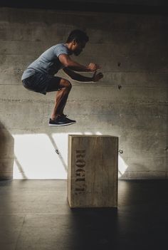 a man jumping over a block with his skateboard