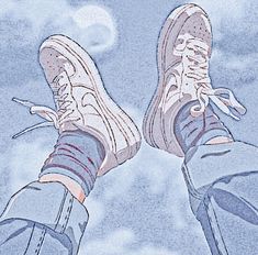 the bottom view of someone's feet wearing blue jeans and white sneakers with clouds in the background