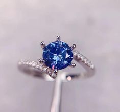 an engagement ring with a blue sapphire surrounded by diamonds