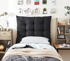 a bed with a black headboard sitting next to a book shelf filled with books