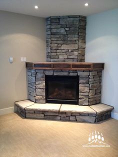 an empty room with a stone fireplace in it