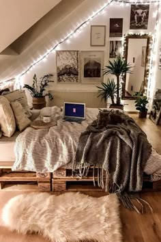 an attic bedroom decorated in white with lights on the ceiling and rugs around the bed