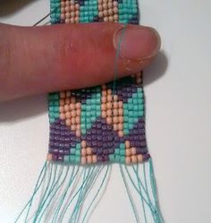 someone is stitching together small pieces of beading with blue and pink beads on them