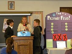 two children and an adult standing at a podium in front of a group of people