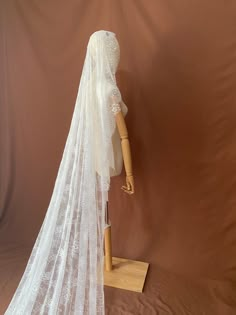 a bridal veil on a mannequin head with a wooden dummy behind it