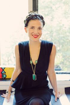 a woman wearing a black dress and necklace