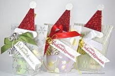 three small gift bags with christmas hats on them