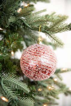 a red ornament hanging from a christmas tree