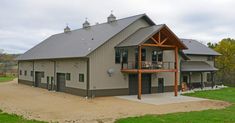 a large house with a covered porch in the middle of a field