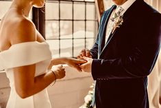 the bride and groom are getting ready to exchange their wedding rings in front of each other