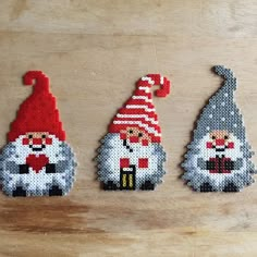 three gnomes made out of beads sitting on a table