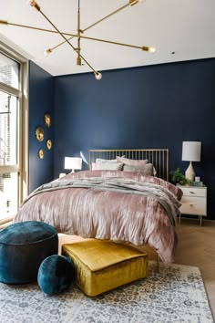 a bedroom with blue walls, gold accents and an upholstered bed in the middle