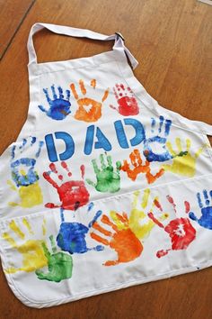 a child's apron with handprints on it that says dad and two hands