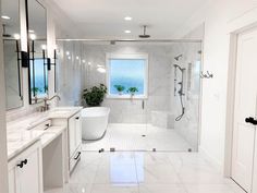 a white bathroom with two sinks and a bathtub