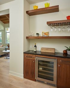 a kitchen with open shelving and wine glasses on the top shelf next to an oven