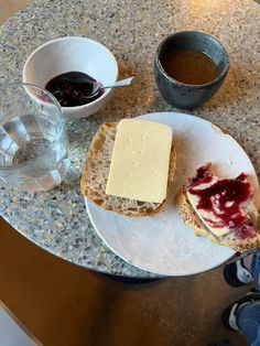 two pieces of bread on a plate with jam and butter