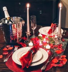 the table is set with candles, plates and silverware for an elegant valentine's day dinner