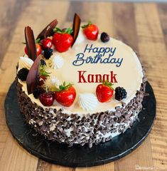 a happy birthday cake with berries and chocolates on the top that says kanak