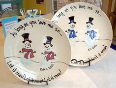 two white plates with snowmen painted on them