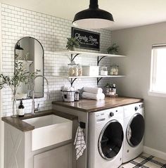 a white washer sitting next to a window in a room with black and white tiles