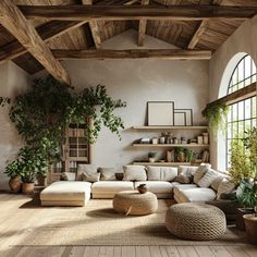 a living room filled with lots of furniture and plants on top of wooden flooring