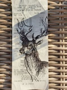 a piece of paper with a drawing of a deer's head on it sitting on a wicker chair