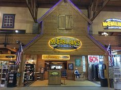 the entrance to a restaurant that is lit up with blue lights and american flags hanging from the roof