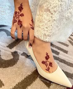 a close up of a person's foot with hennap and flowers on it