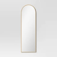 an arched mirror on a white wall