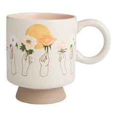 a white coffee cup with flowers painted on the side and hands holding roses in each mug